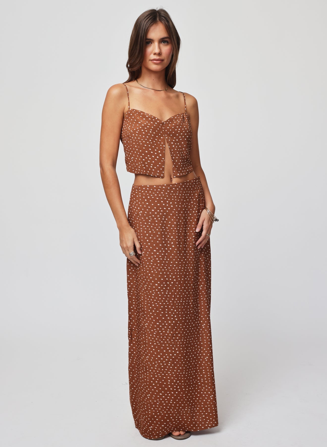 Woman wearing a brown polka dot split crop top and skirt