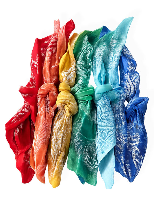 Six pale cotton bandanas, knotted and laid in a row, evoke a relaxed beach vibe.