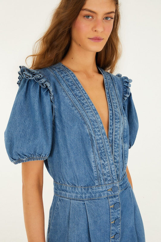 Blue denim romper with puff sleeves, ruffle trim, and deep V-neck; casual wear suitable for warmer weather.