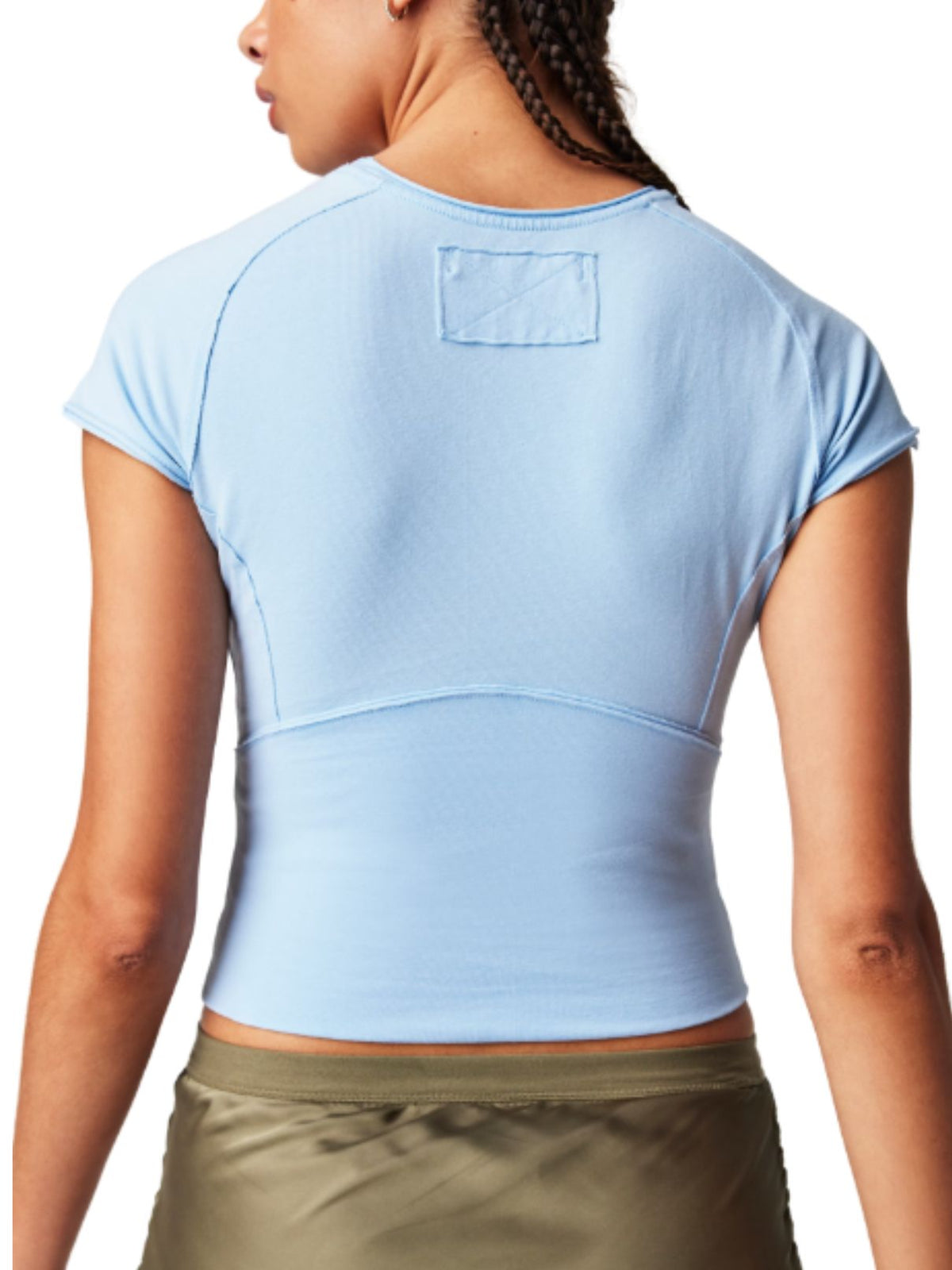 Back view of a person with braided hair in a blue tee and olive green pants, highlighting fabric and fit.