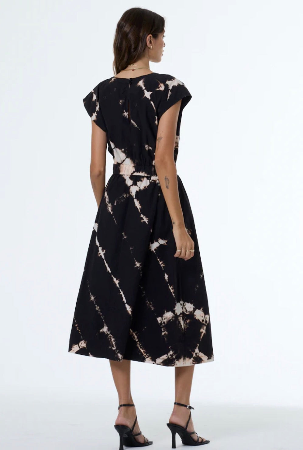 Back view of woman in tie-dye top, lightweight fabric, suitable for casual wear.