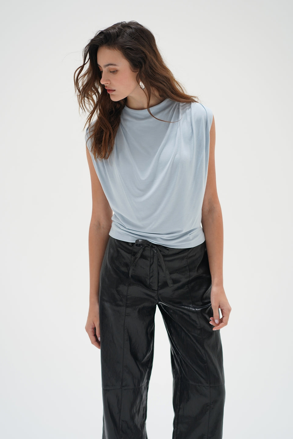 Woman in a light blue drape neck sleeveless top