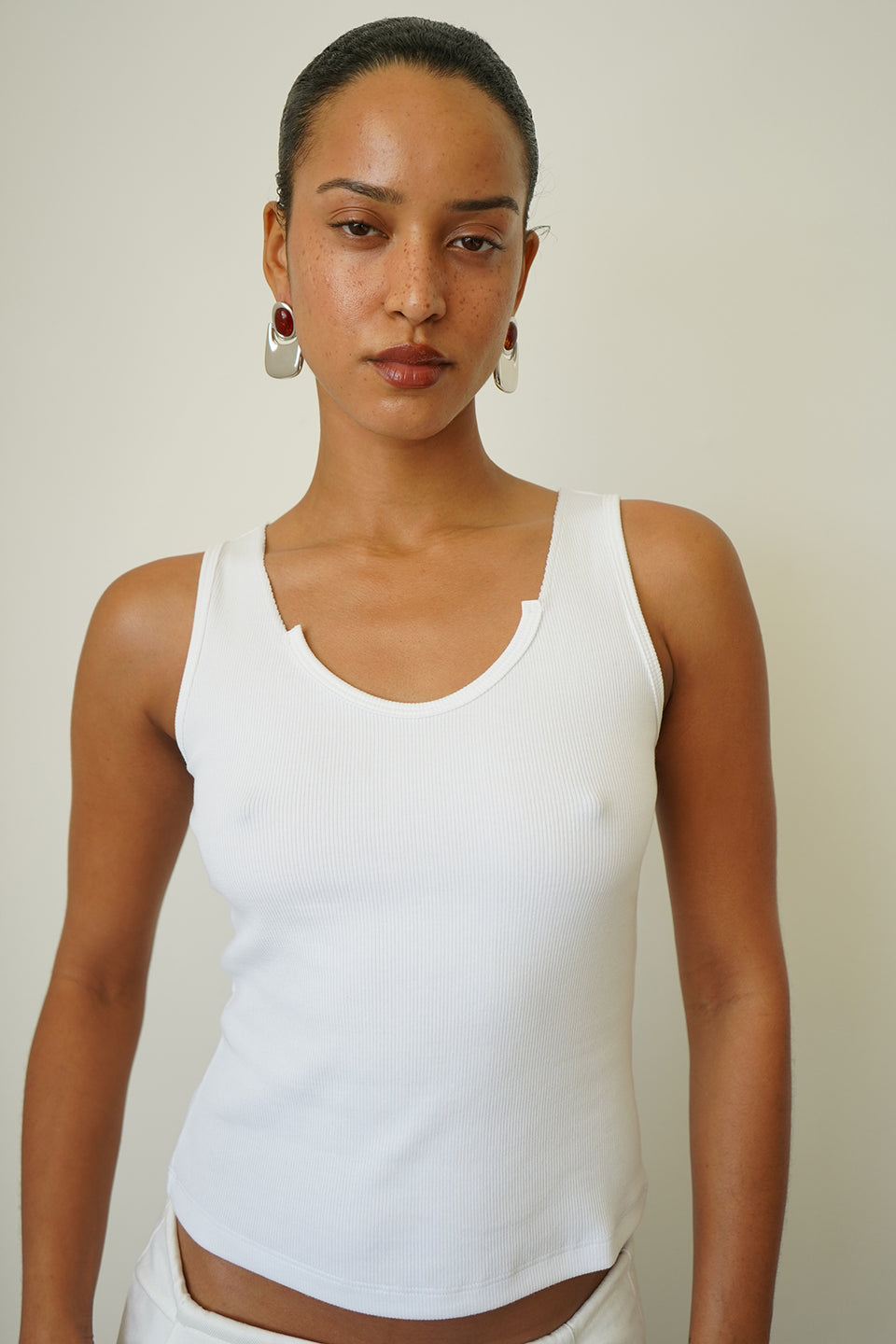 Woman wearing a white ribbed tank top