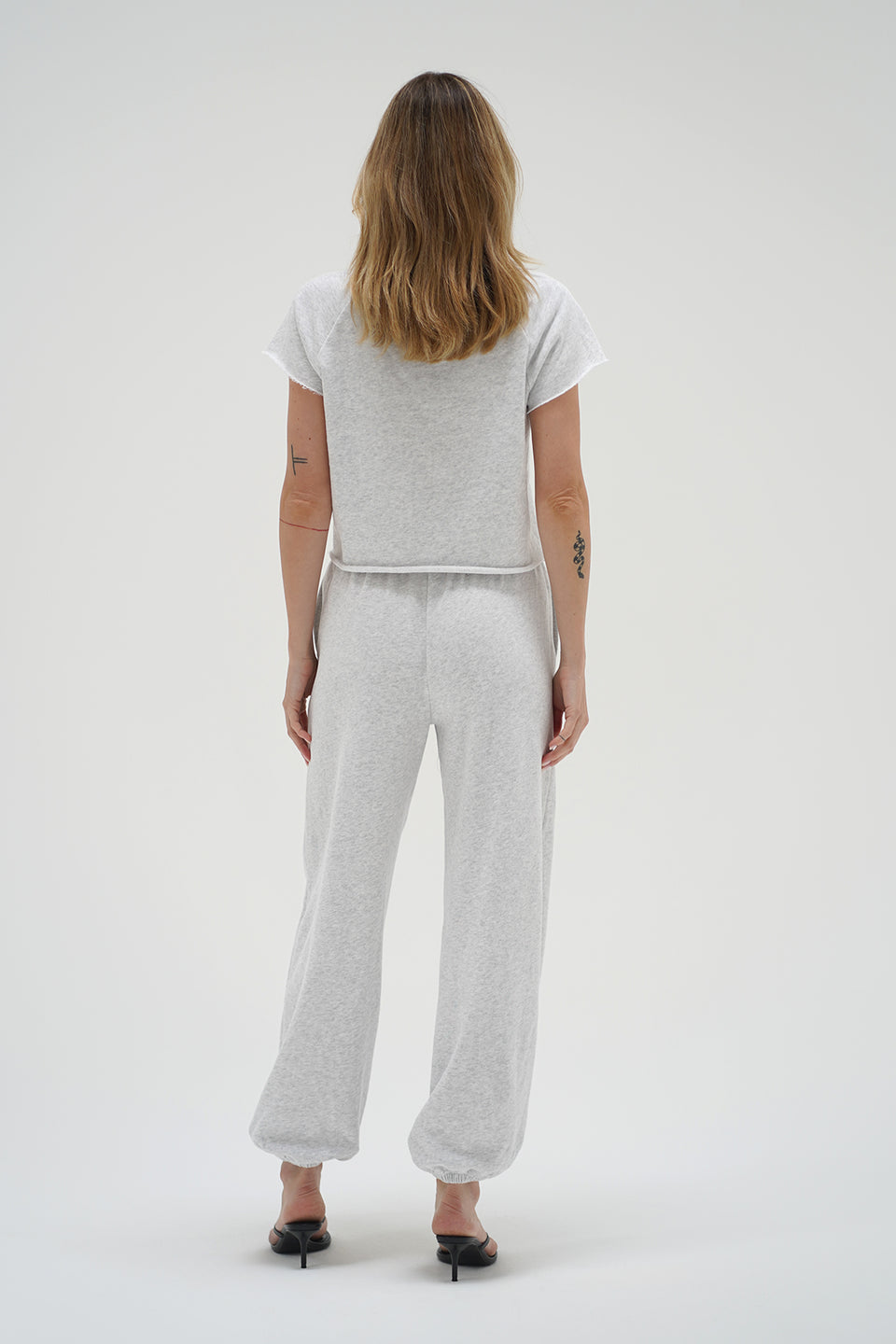 Woman wearing light heather grey sweatpants and short sleeve sweatshirt