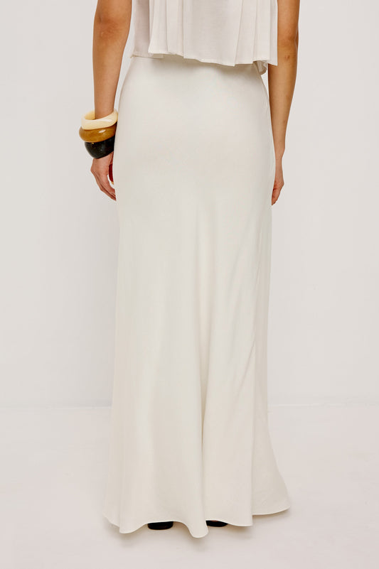 Ivory midi skirt in lightweight fabric, styled with a sleeveless top and chunky bangles against a plain background.