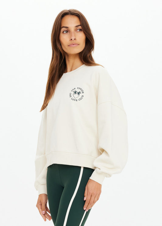 Cream crewneck sweatshirt paired with green leggings featuring white stripes, shown against a plain white background.