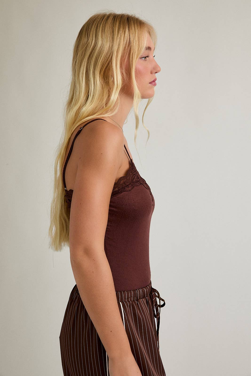 Woman wears brown bodysuit, likely knit material
