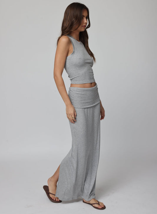 Woman wearing a gray sleeveless top and long skirt 