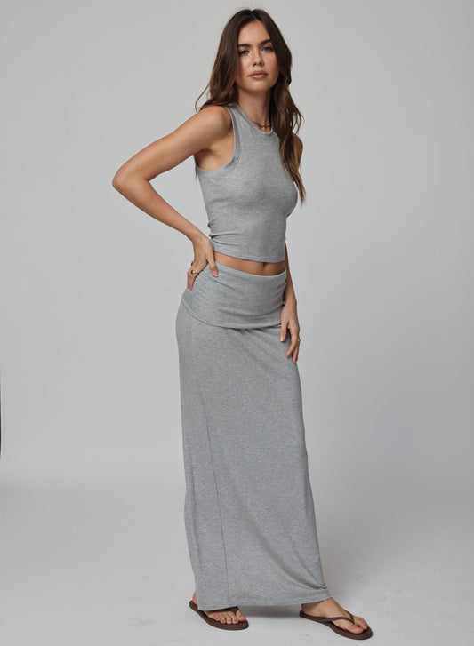 Woman wearing a gray sleeveless top and long skirt 