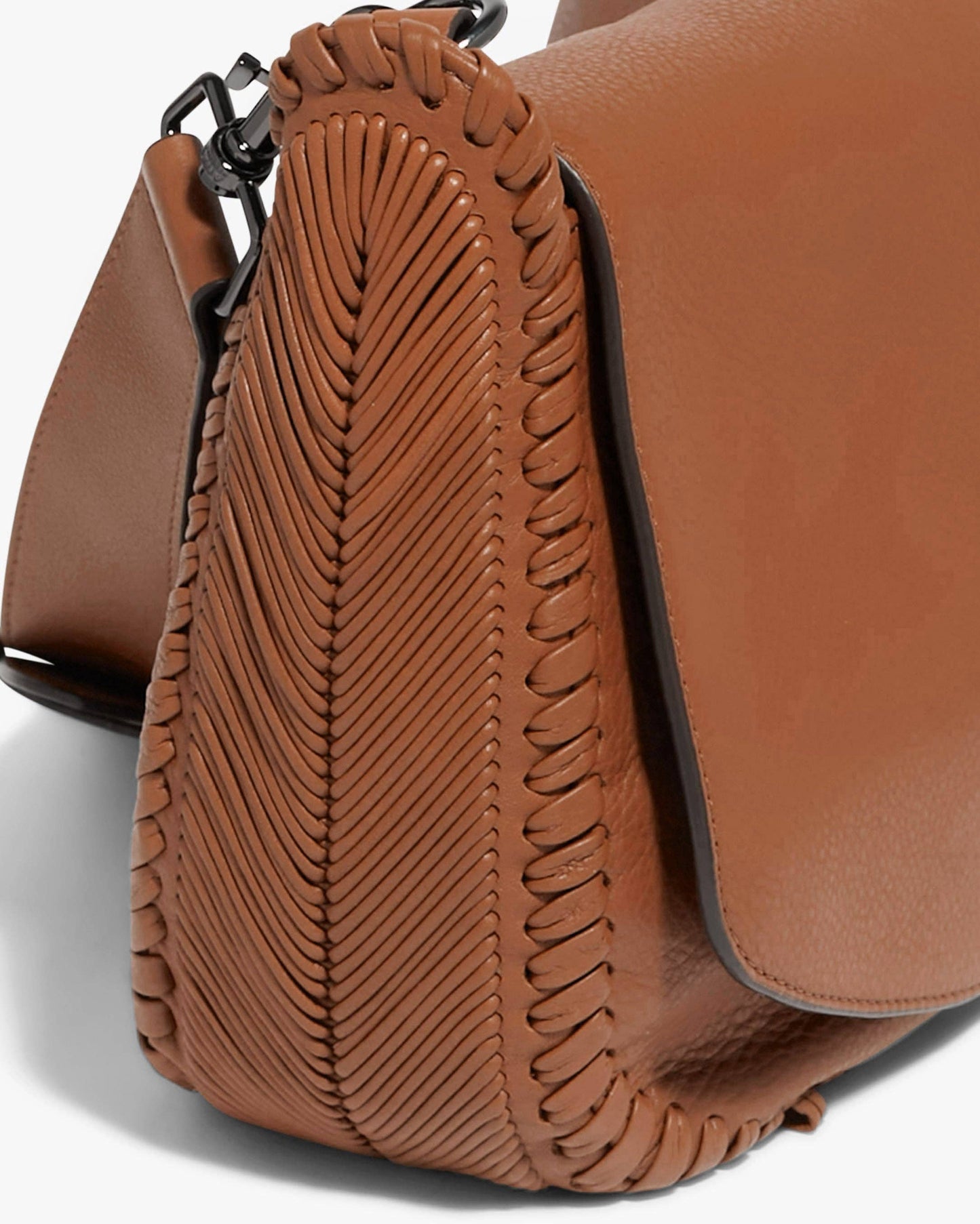 Brown leather saddle crossbody bag with woven stitching and adjustable flap strap, suitable for daily use.