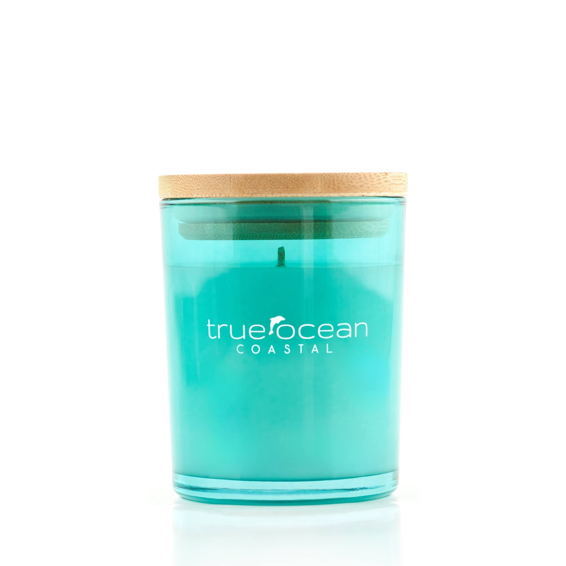 Turquoise soy wax candle in glass jar with wooden lid; features a coastal scent. Suitable for home use.