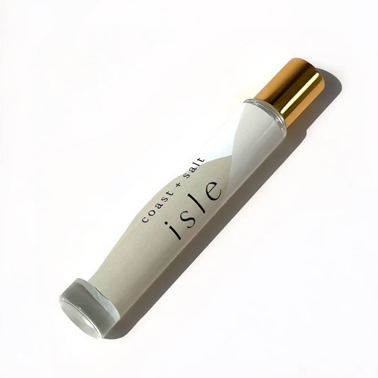 Gold-capped Isle perfume roller by Coast+Salt, clear glass, on a white surface; designed for easy fragrance application.