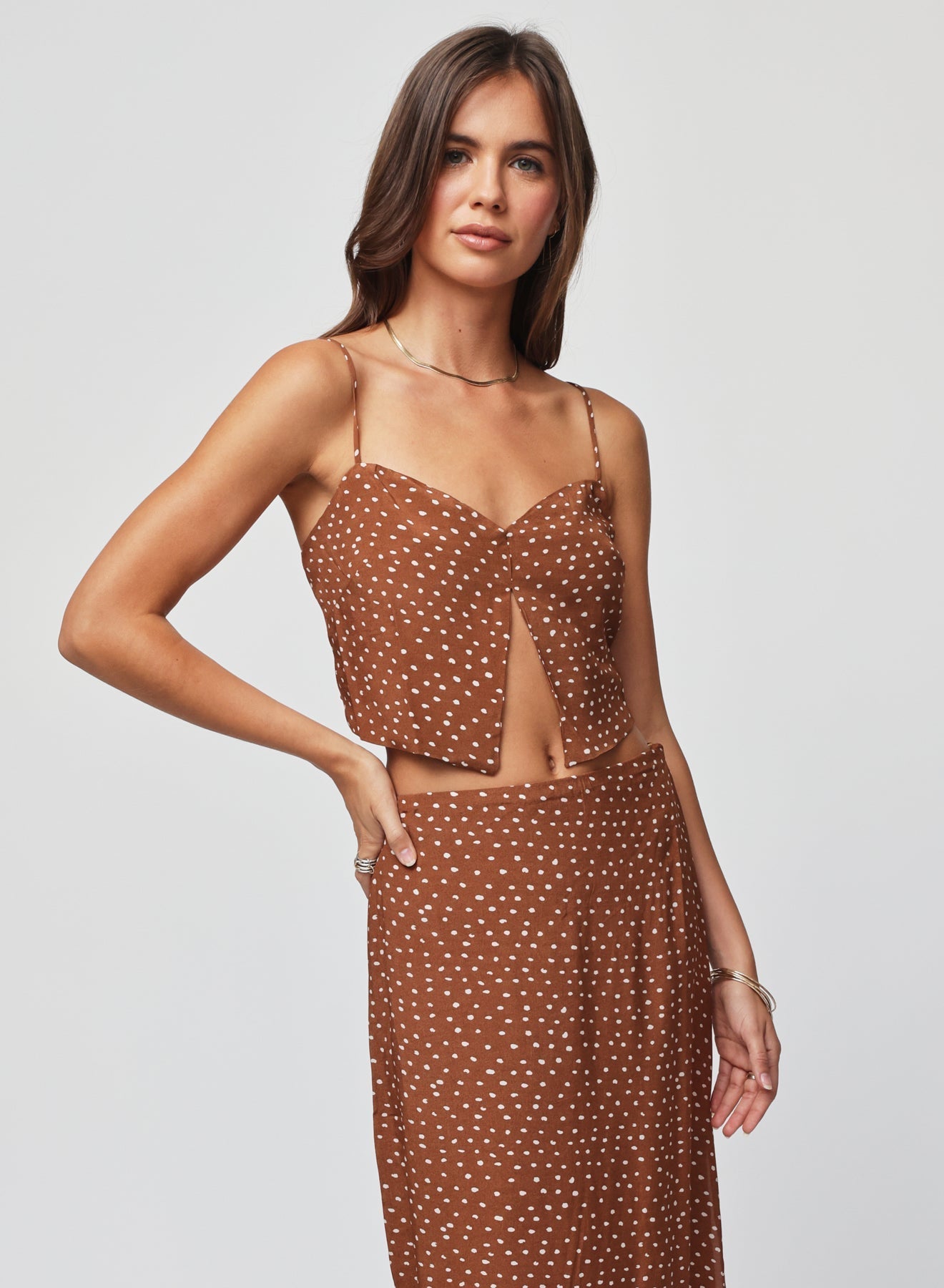 Woman wearing a brown polka dot split crop top