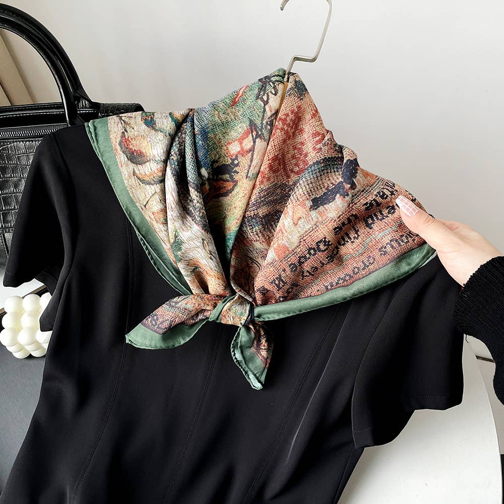 A black dress on a hanger with a paisley patchwork bandana tied at the collar, shown being held by hand.