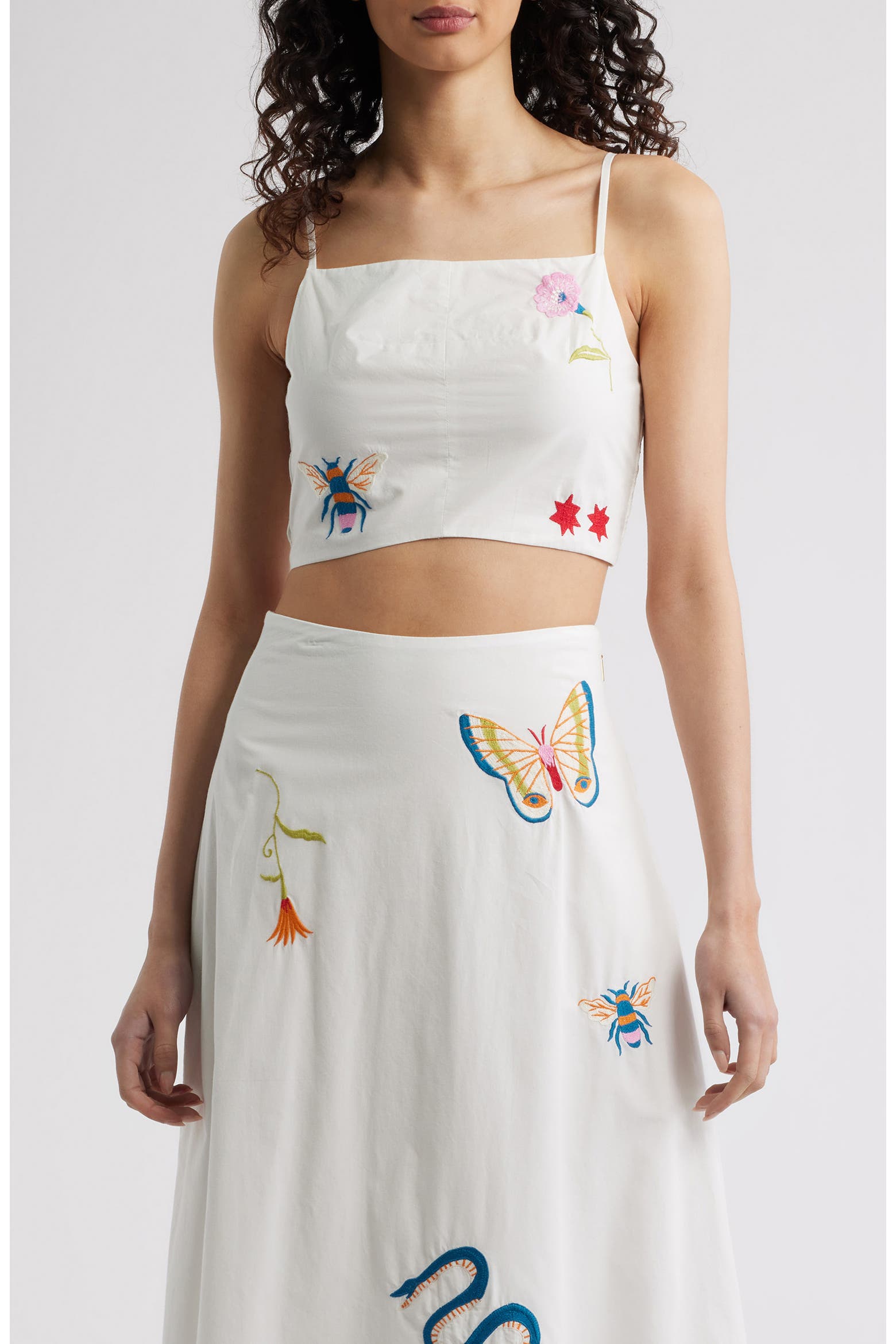 Woman in a white top with colorful designs 