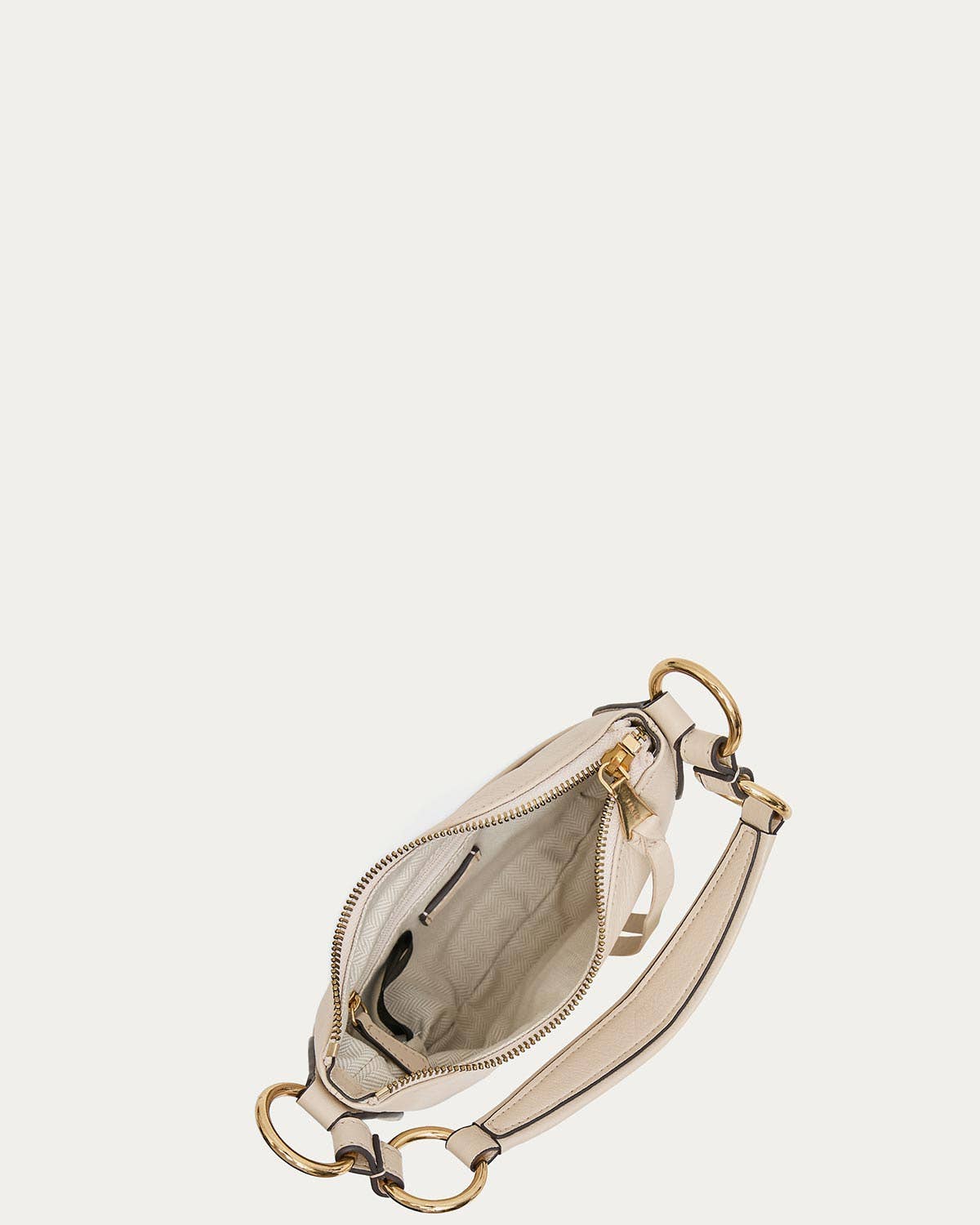 Limestone crossbody bag with gold hardware, bold strap, and open top revealing interior pockets.