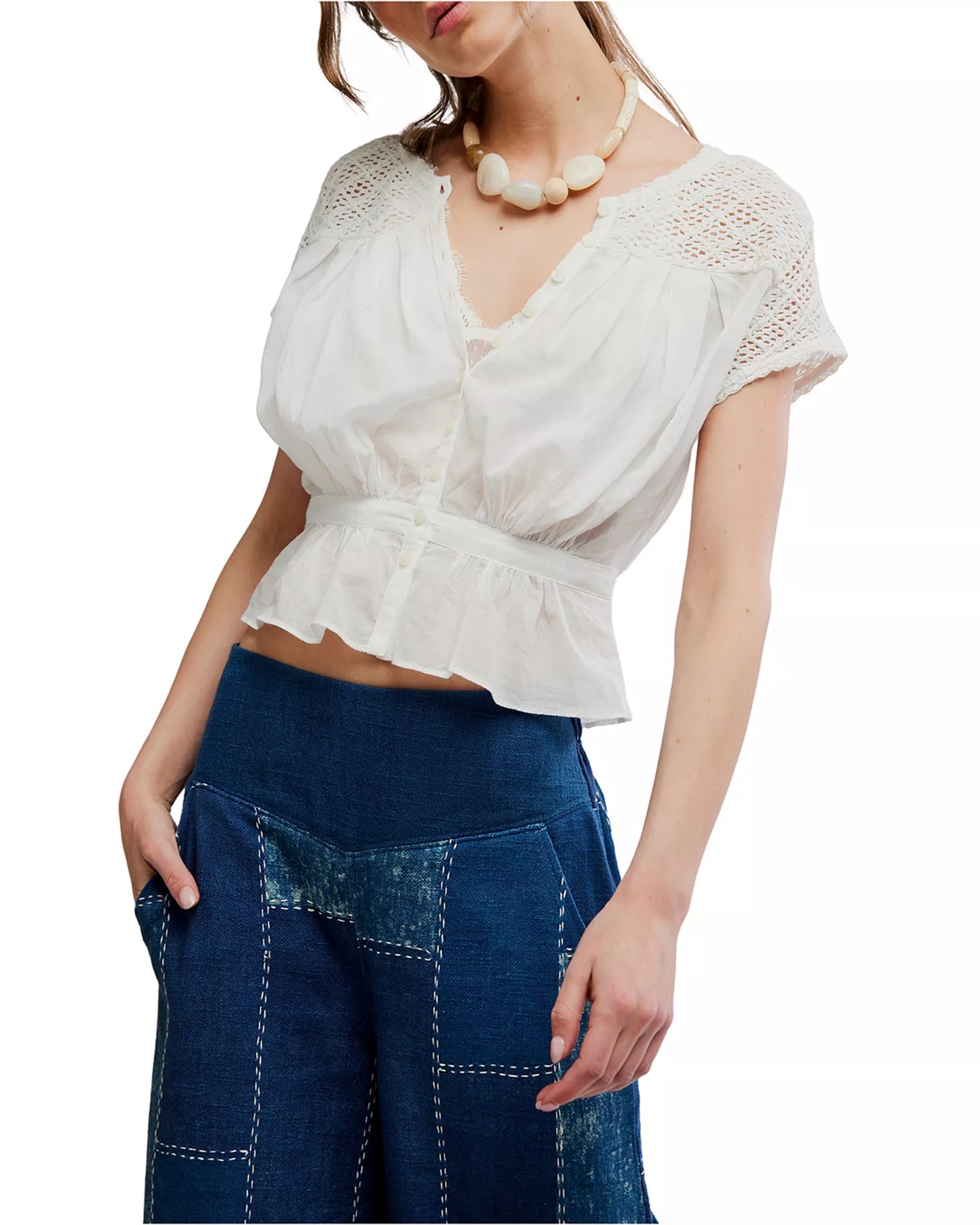 Ivory embroidered top paired with blue high-waisted patchwork jeans, suitable for casual outings.