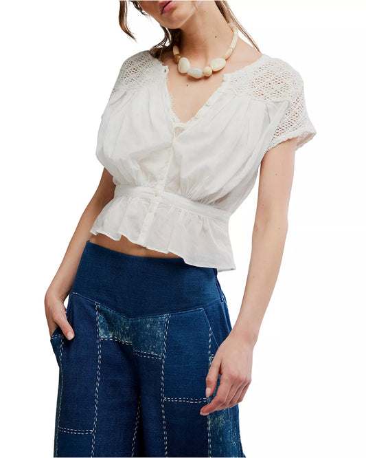 Ivory embroidered top paired with blue high-waisted patchwork jeans, suitable for casual outings.