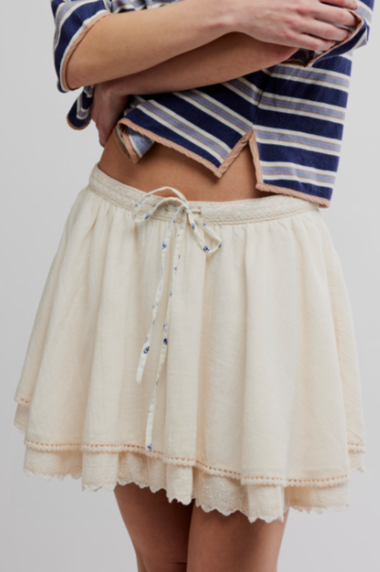 Woman in striped top and tea-colored mini skirt with crochet-lace waistband and lace trim, suitable for casual wear.
