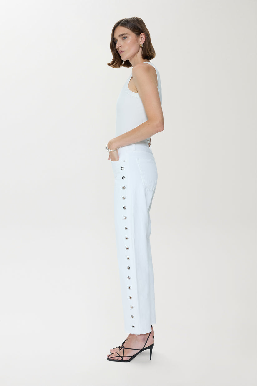 Woman wearing a white denim outfit with studded details