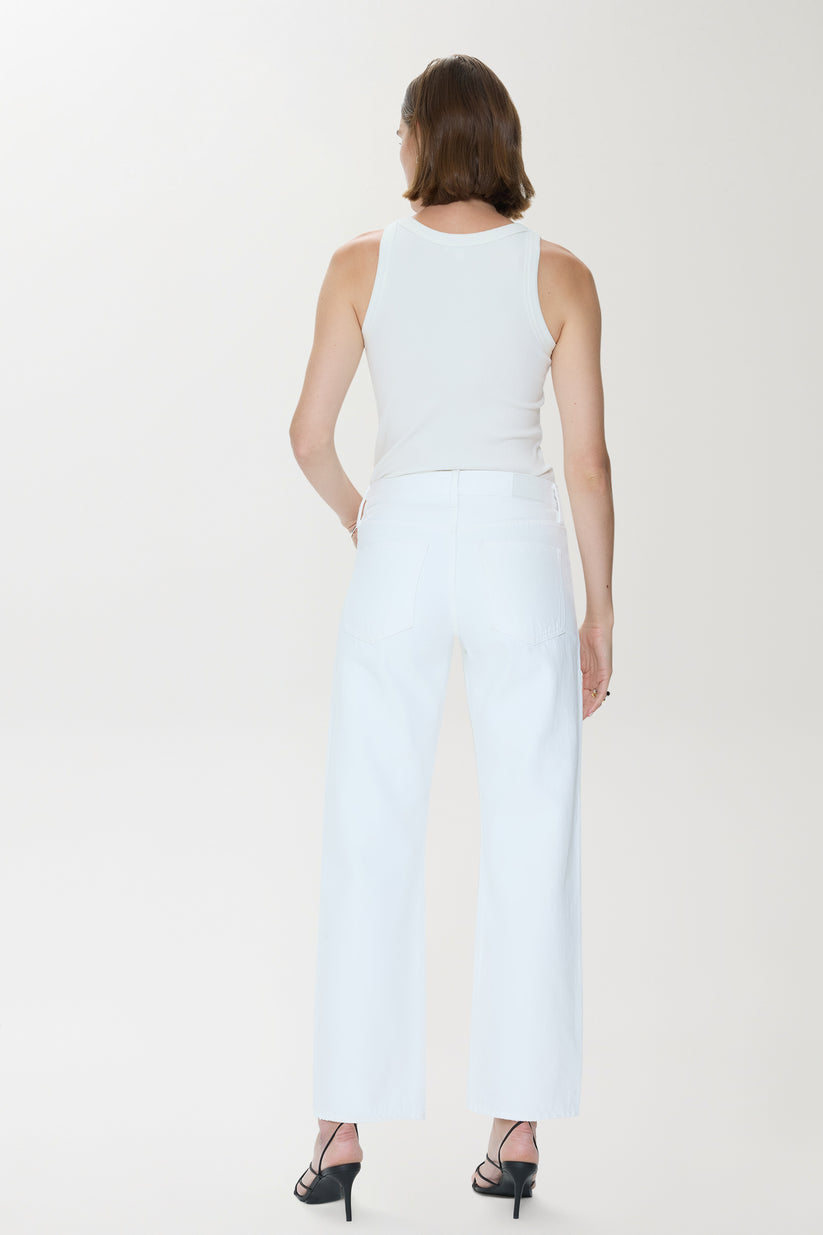 Woman wearing a white denim outfit with studded details