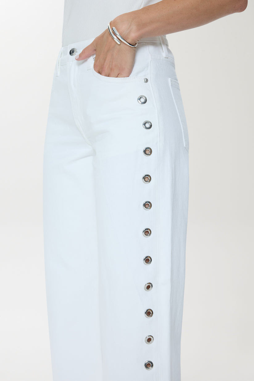 Woman wearing a white denim outfit with studded details