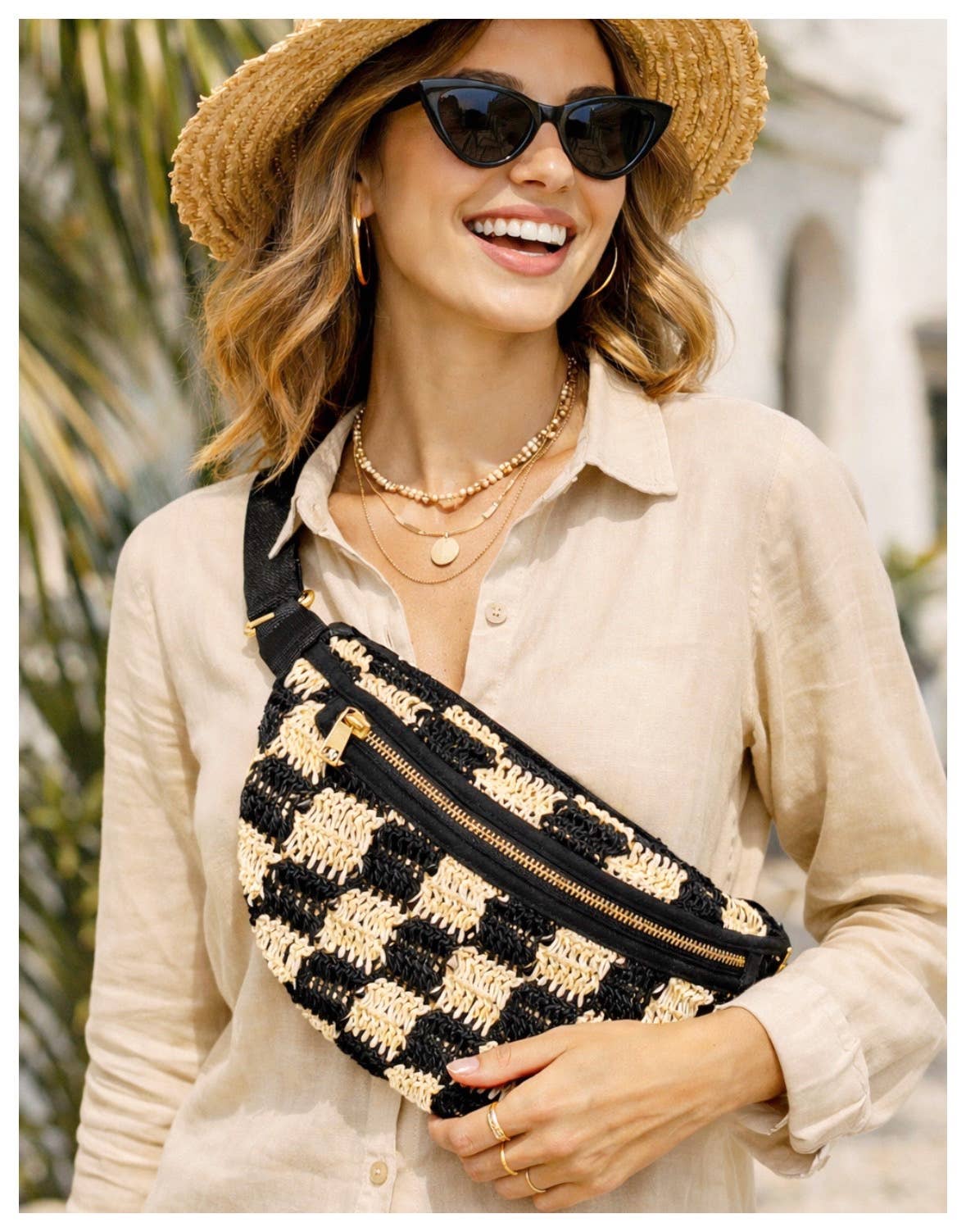 Woman in sunglasses and straw hat wears a beige shirt with a checkered fabric sling bag, suitable for everyday use.