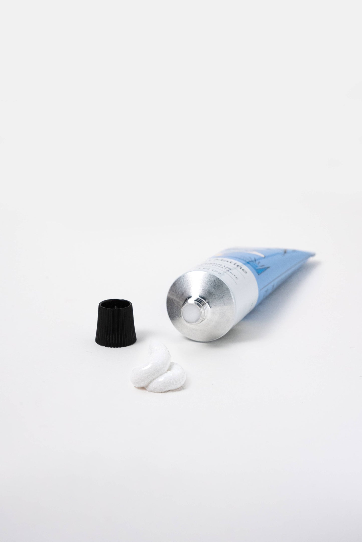 Blue Maison Matine Minus Cumulus hand cream tube, cap off, with two white cream blobs on a white background.