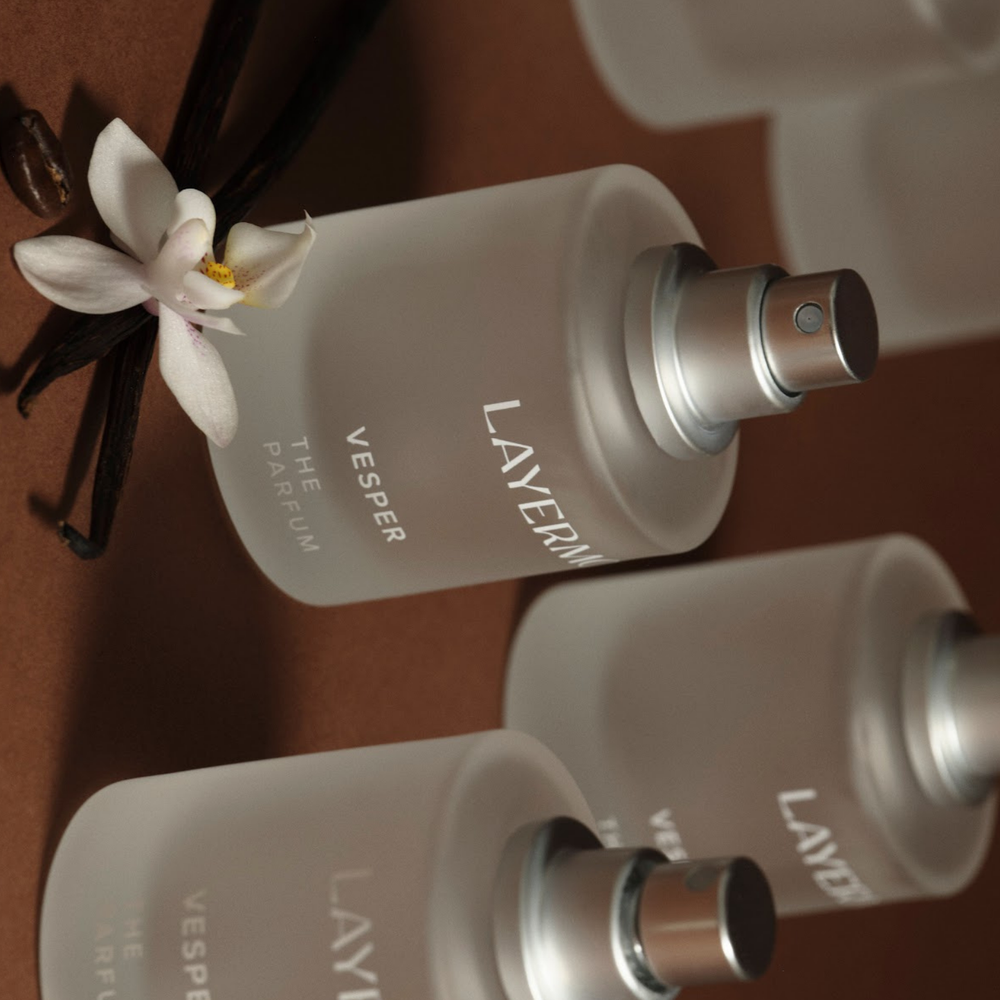 Frosted glass perfume bottles labeled Vesper, featuring a subtle vanilla and white floral scent.