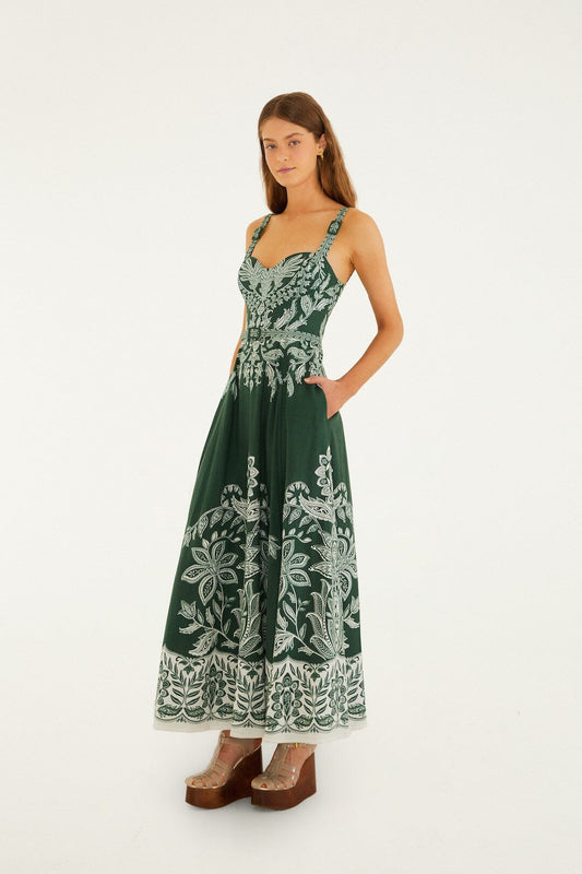 Dark green maxi dress with belt buckle details and pockets, styled with brown platform sandals.