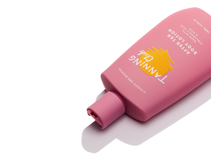 Pink plastic bottle of after-tan body lotion with aloe and yellow sun graphic, placed on a white surface.