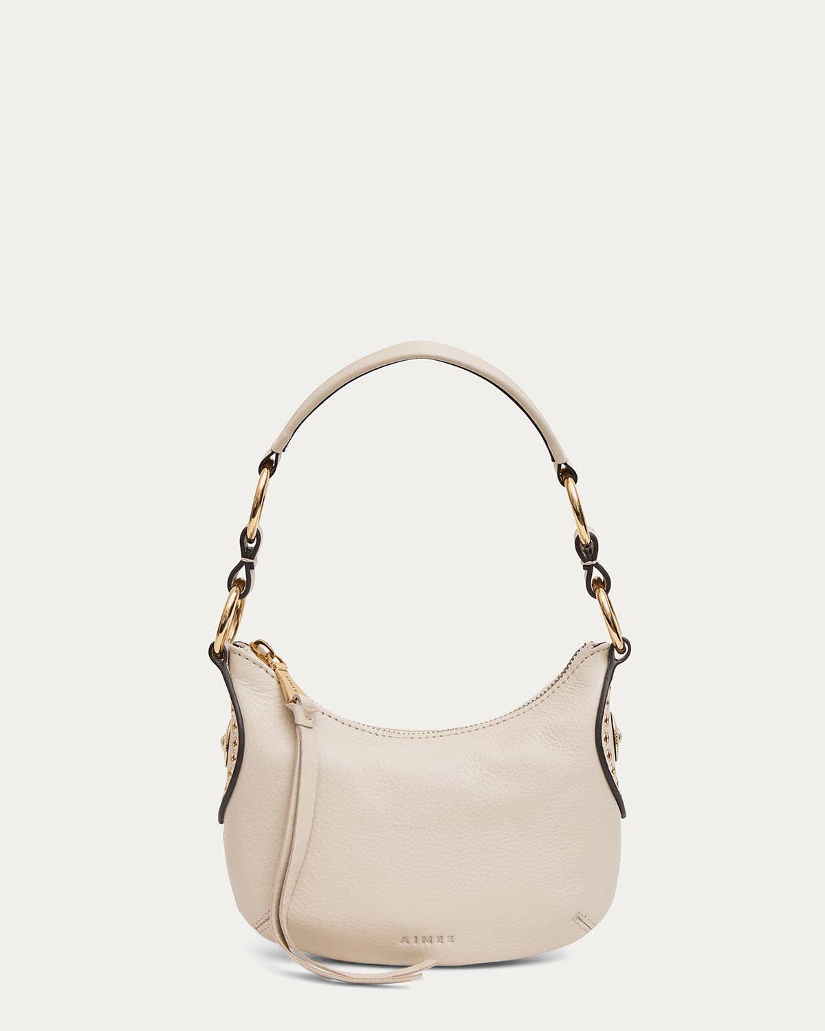 Limestone mini crossbody bag with gold hardware, short handle, and zippered top; suitable for everyday essentials.