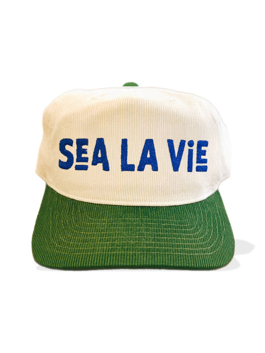 White and green corduroy hat with blue embroidered front lettering; casual headwear suitable for everyday use.