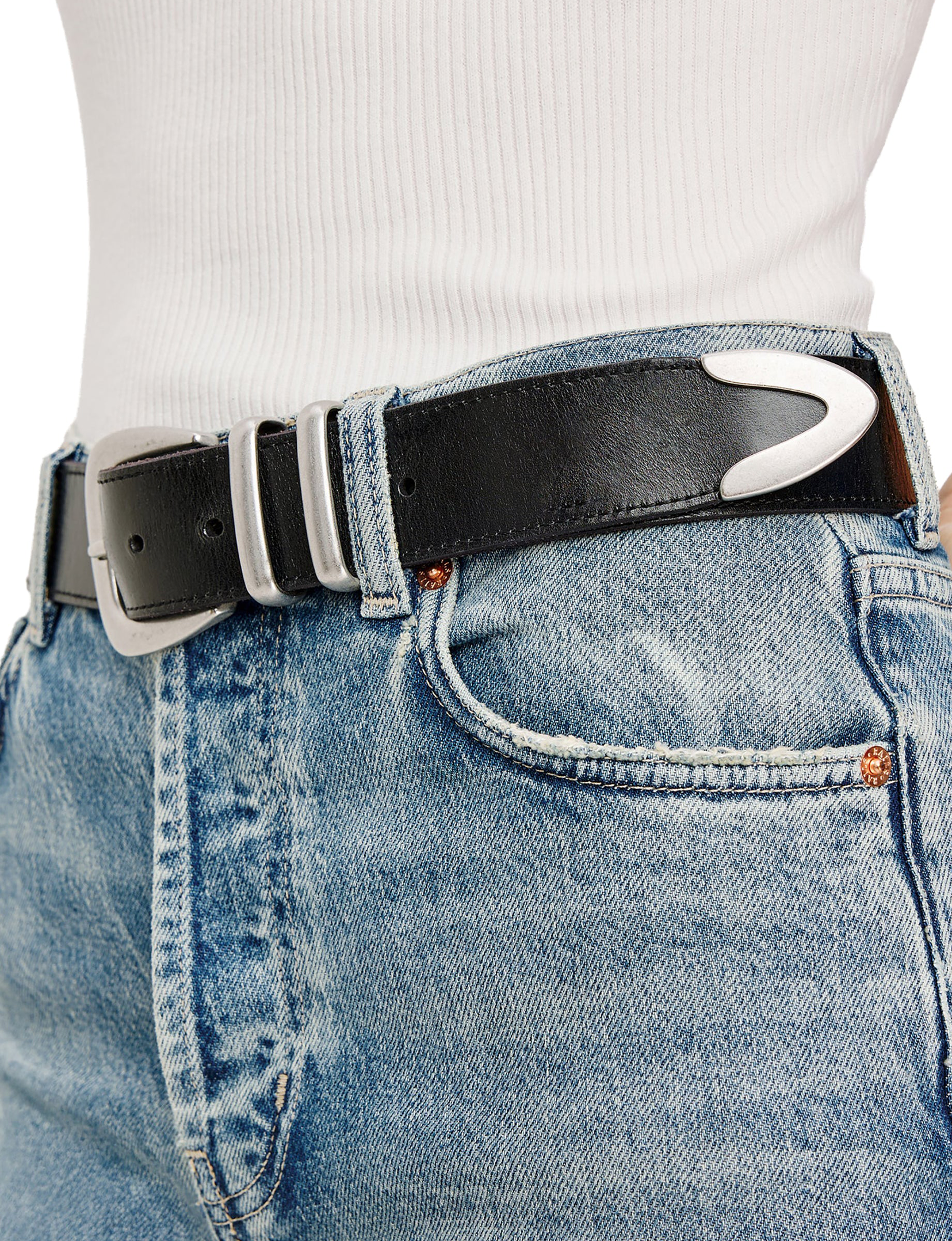 Individual in light blue jeans, white ribbed top, and a black belt with a distinctive silver buckle.