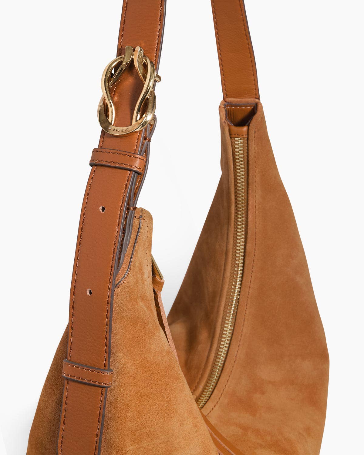 Brown suede shoulder hobo bag with curved zipper and gold buckle, suitable for carrying essentials.