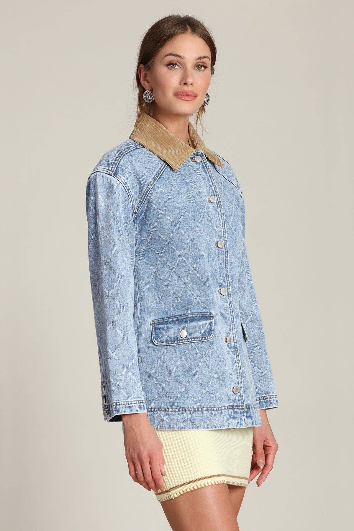 Woman in blue denim barn jacket with tan collar, paired with cream skirt; casual weekend outerwear.