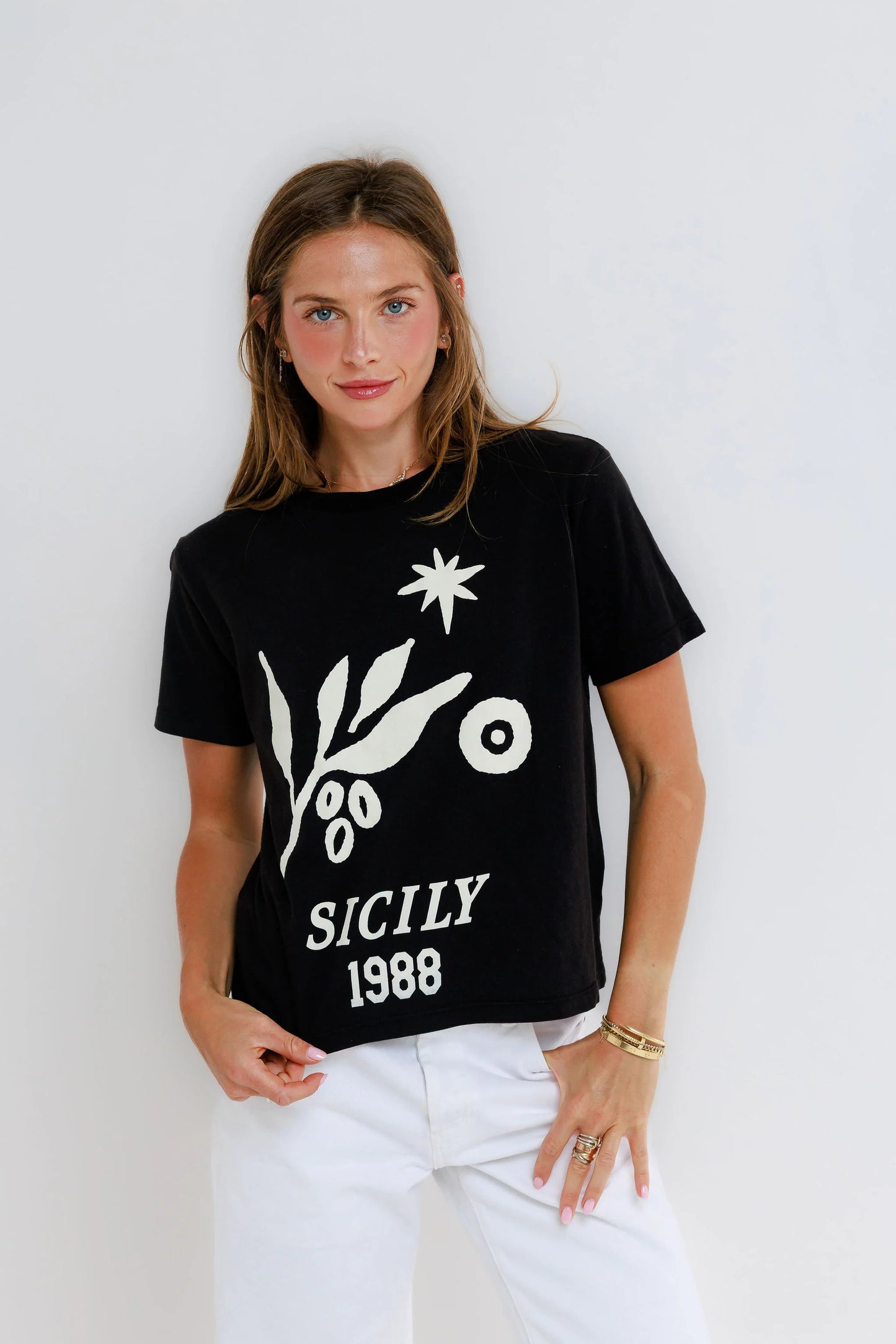 Black vintage Everyday Tee and black and white pants made of cotton, shown on a woman standing against a plain white background.