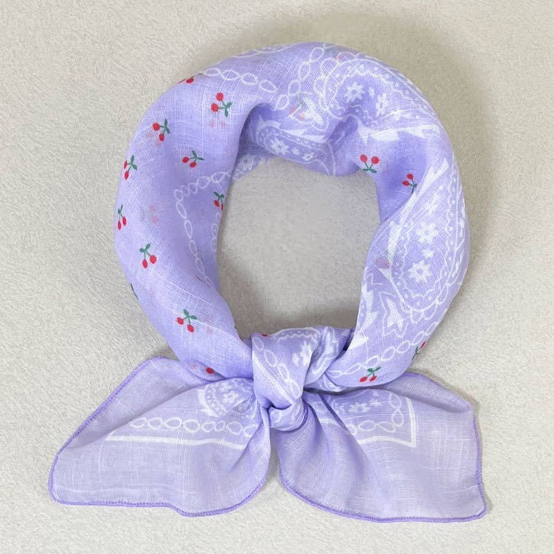 Light purple bandana with white and red cherry print, tied next to a beaded headband.