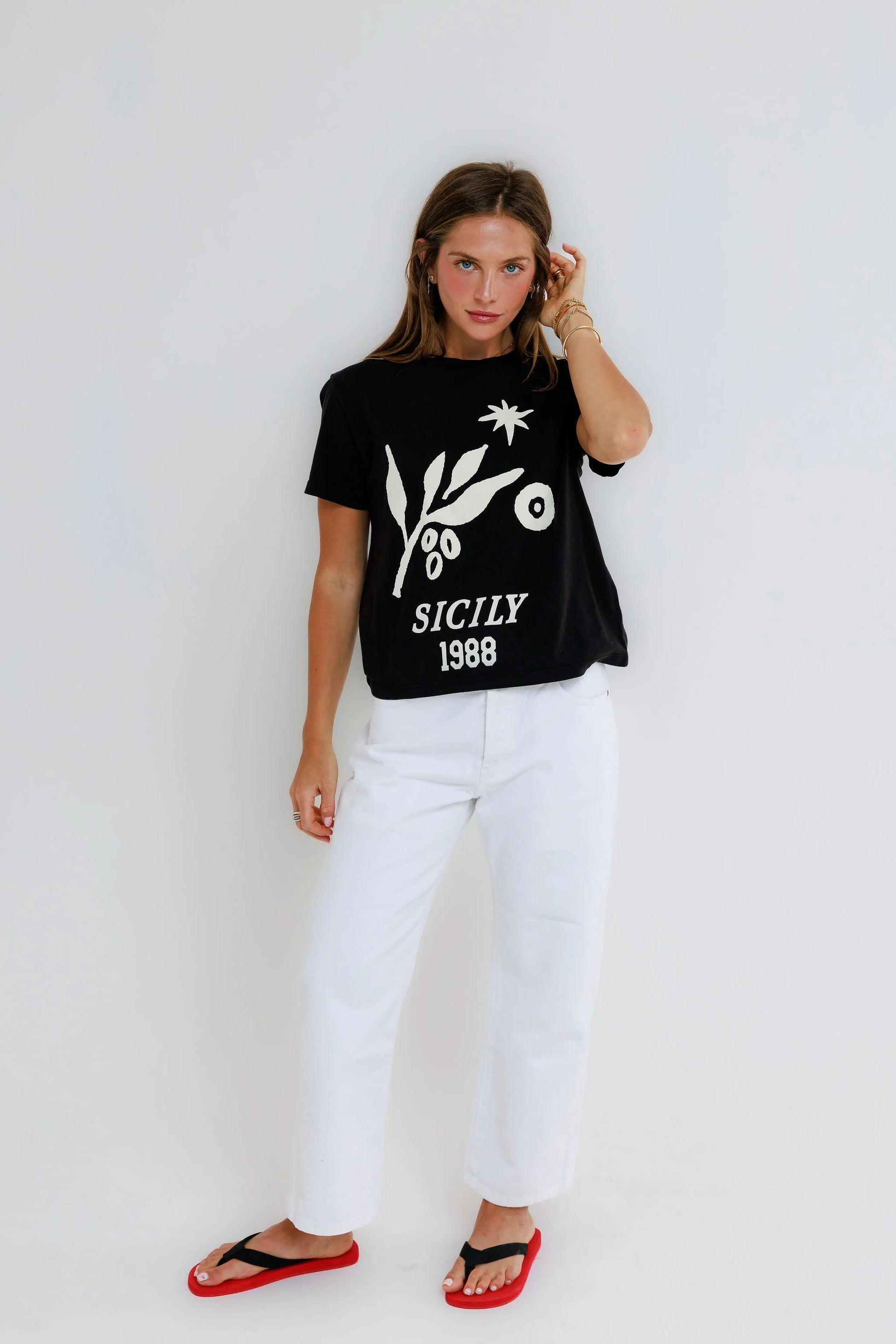Vintage black everyday tee, white pants, and red sandals displayed on a white background. Casual cotton outfit ensemble.