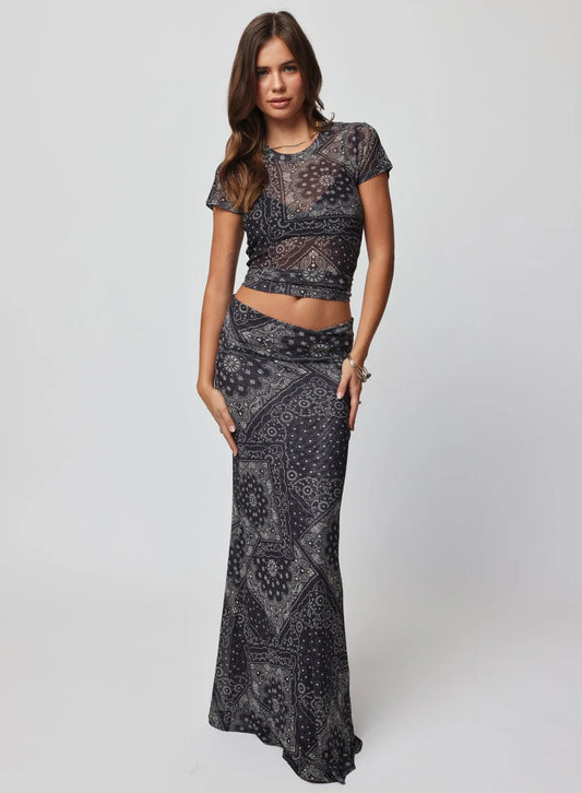 Woman wearing a black paisley patterned outfit on a white background