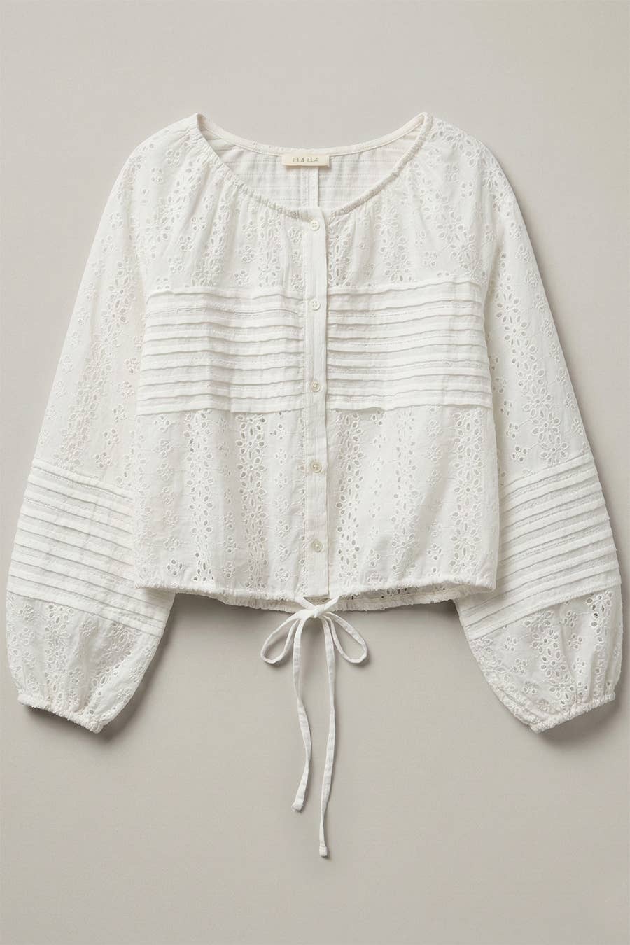 Off-white long-sleeve top with eyelet buttons, pleats, and adjustable drawstring waist for everyday wear.