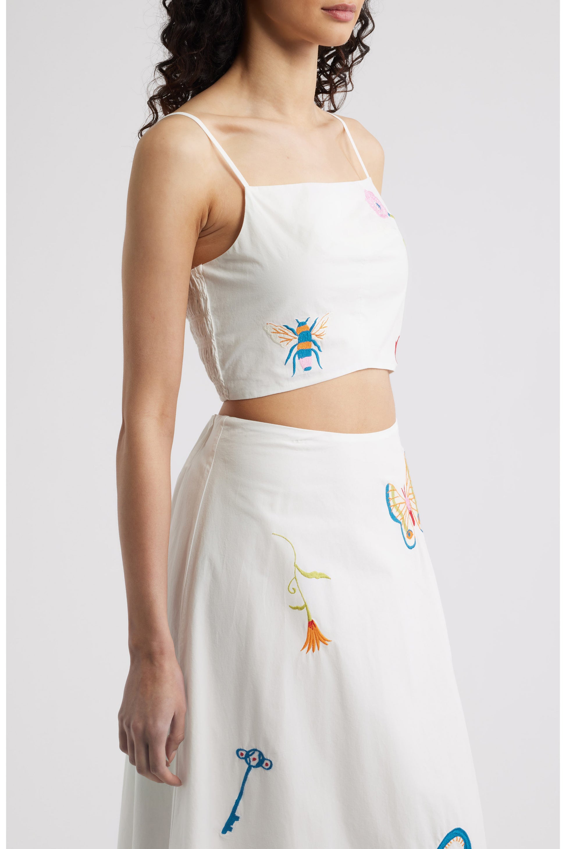 Woman in a white top with colorful designs 