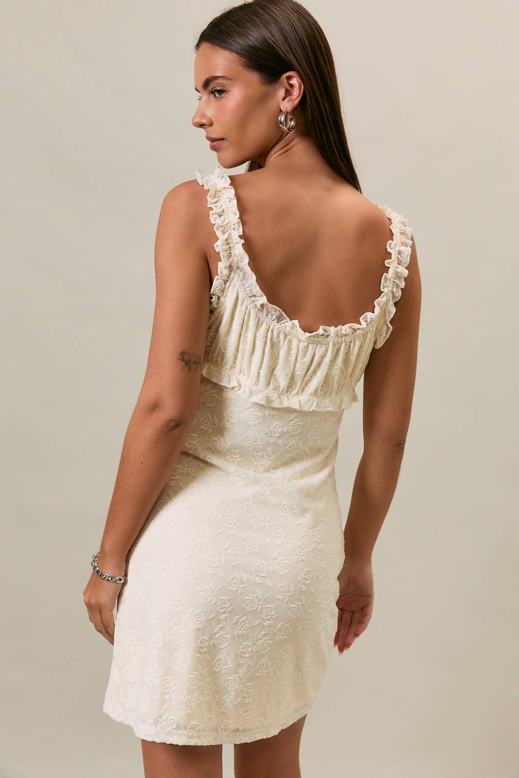 Sleeveless cream mini dress, shown from the back against a plain background.