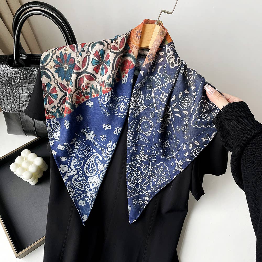 Blue and red paisley patchwork bandana draped over a black dress on a hanger. Cotton fabric, casual accessory use.