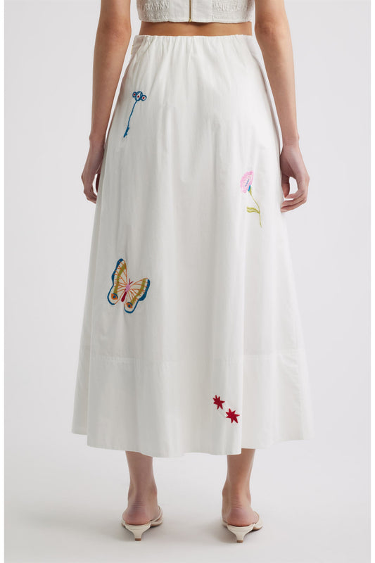 Woman in a white skirt with colorful embroidery