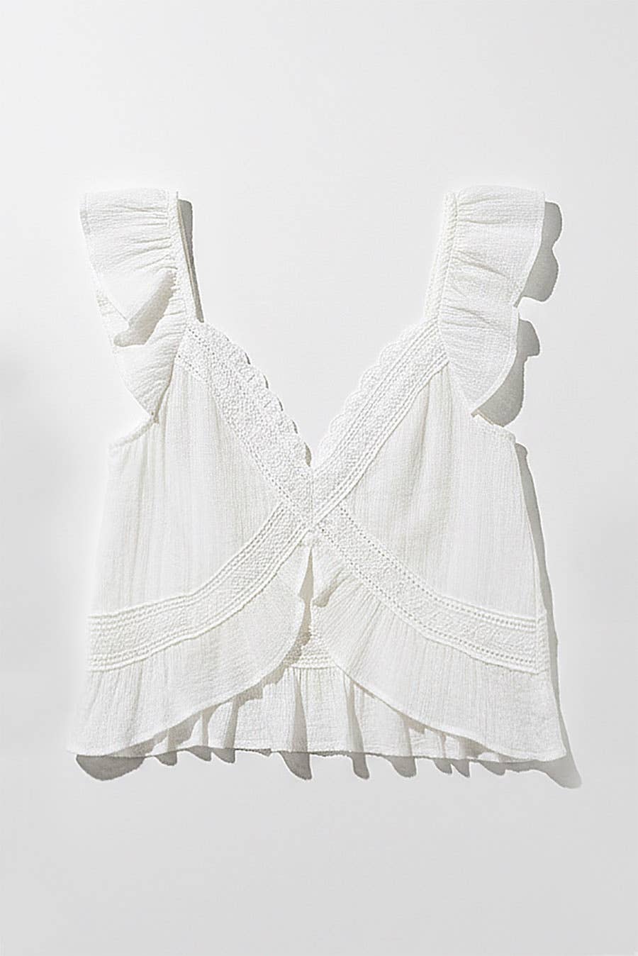 Natural ruffle sleeve top with crochet lace accents and wrap V-neck, made of lightweight fabric, on plain background.