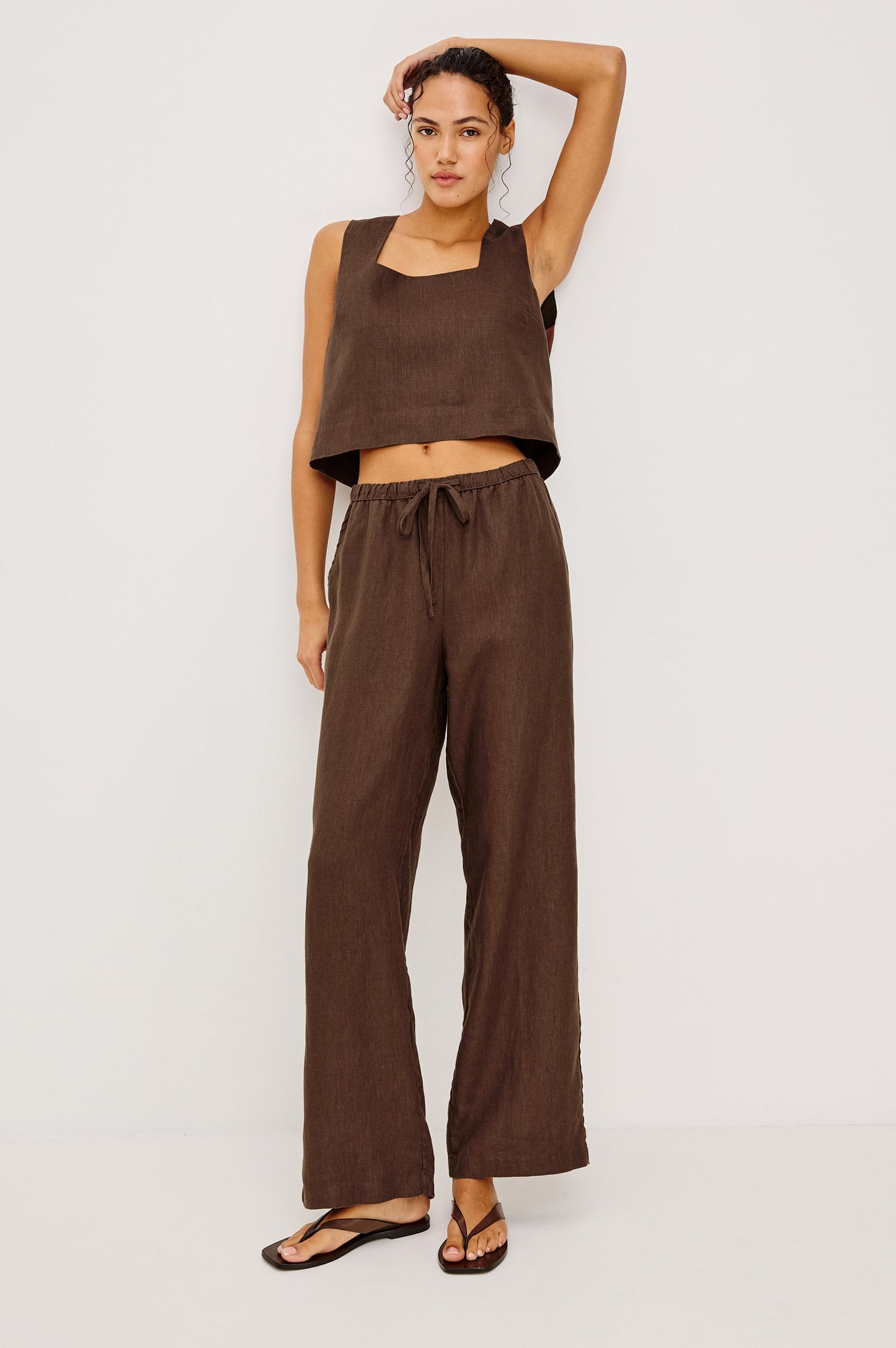 Sleeveless linen top in espresso with a square neckline, shown on a woman against a white background.