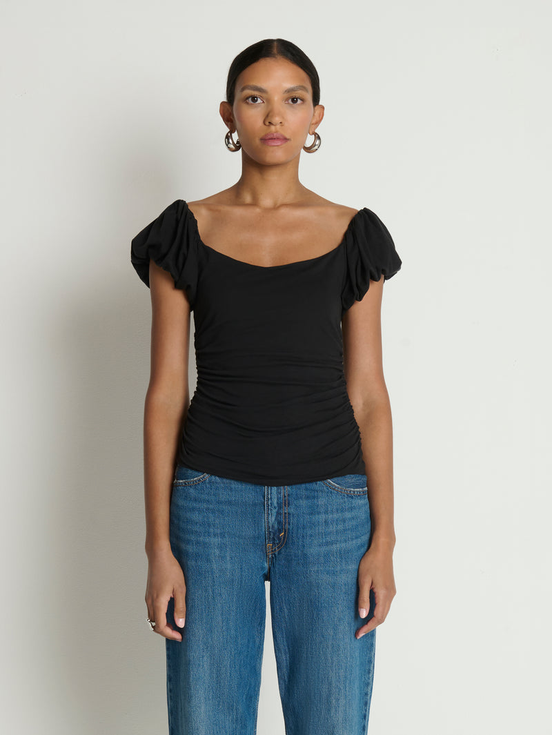 Woman wearing a black top with ruffled sleeves 