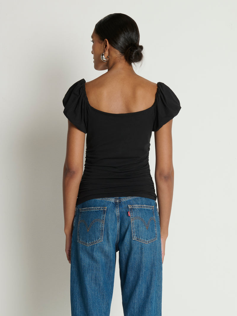 Woman wearing a black top with ruffled sleeves 