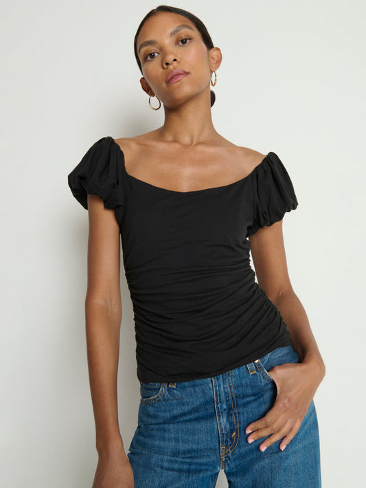 Woman wearing a black top with ruffled sleeves 